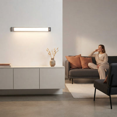 A sleek wireless motion-sensor LED light illuminating a stylish, modern living room with terracotta and charcoal decor.